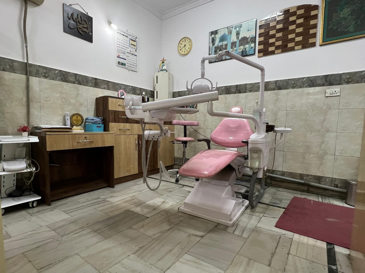 Treatment room with a pink dental chair and wooden cabinets, Neodent Dental Hospital, Mehdipatnam
